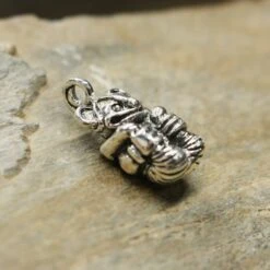 Gripping Bear Pendant -The Viking Dragon Shop ad silver gripping bear pendant on rock side view