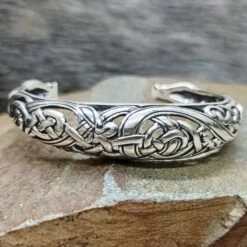 Silver Urnes Dragon Bracelet -The Viking Dragon Shop ad silver urnes dragon arm ring bracelet on rock front view