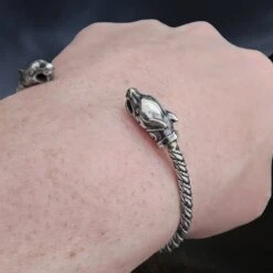 Slim Twisted Silver Viking Bracelet With Ferocious Wolf Heads -The Viking Dragon Shop bt silver twisted bracelet ferocious wolf heads slim on wrist angle view
