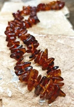 Polished Amber Chip Necklace -The Viking Dragon Shop eg polished dark amber chip necklace on rock close