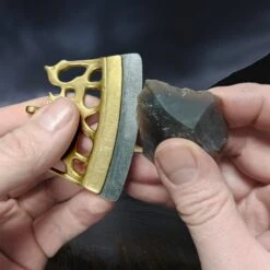 Bronze Finnish Fire Striker With Flint Flake -The Viking Dragon Shop mc bronze viking age fire steel from finland in fingers with flint