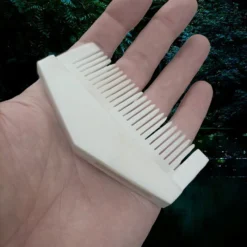 Triangular Bone Viking Comb -The Viking Dragon Shop nc triangular bone comb on hand back angle view