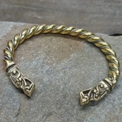 Twisted Bronze And Silver Bracelet With Gotlandic Dragon Heads -The Viking Dragon Shop sn bronze silver twisted bracelet gotland dragon heads on rock front angle view