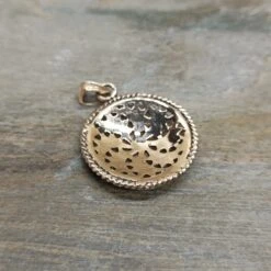 Bronze Sun Wheel Pendant -The Viking Dragon Shop sn bronze sunwheel pendant on rock back view