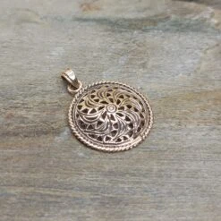 Bronze Sun Wheel Pendant -The Viking Dragon Shop sn bronze sunwheel pendant on rock front angle view