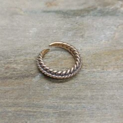 Bronze Braided Viking Ring -The Viking Dragon Shop wl twisted bronze viking ring on rock front angle view