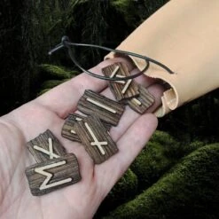 Elder Futhark Wooden Rune Set In Leather Pouch -The Viking Dragon Shop wl wooden elder futhark runes in hand with medium leather pouch close up